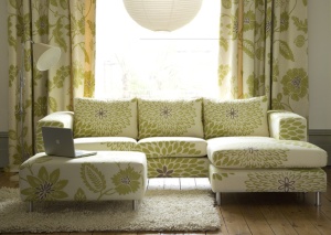 a yellow and white patterned sofa with curtains in the same fabric